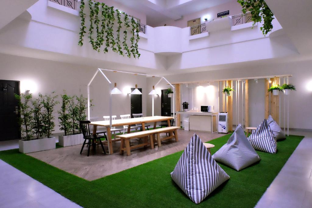 salon ze stołem i zielonym dywanem w obiekcie Siam Mansion - SHA w mieście Hat Yai