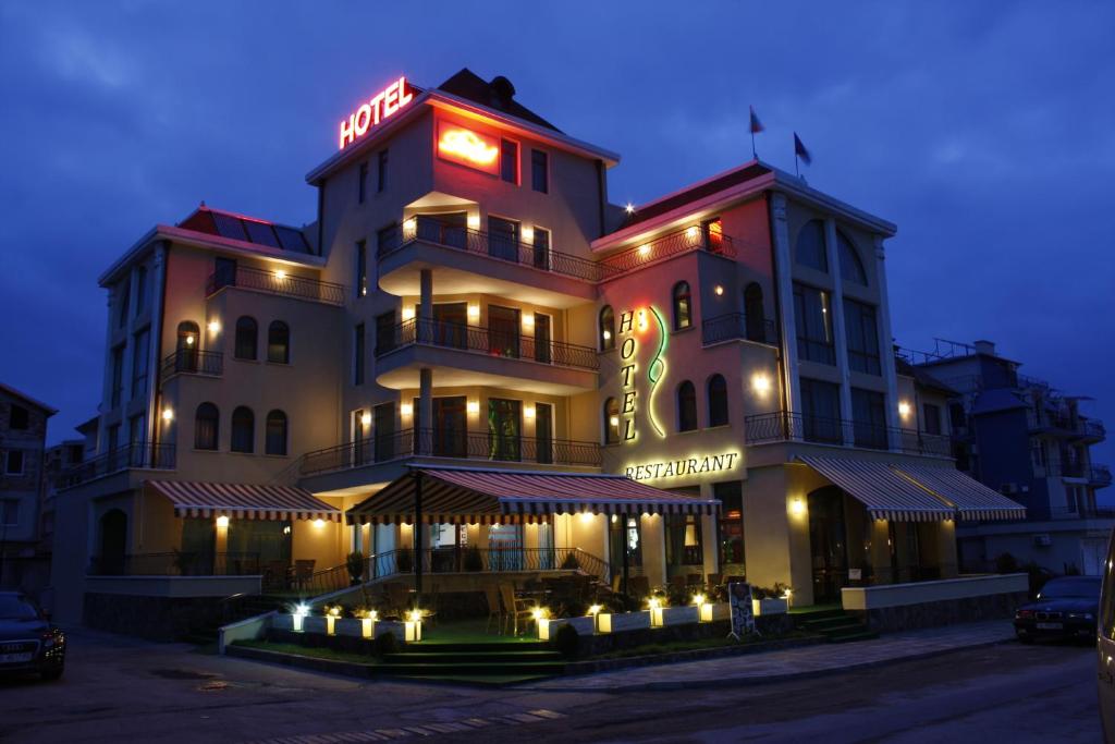 a large building with a sign on it at night at Hotel Dukov in Obzor
