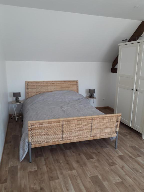 sypialnia z łóżkiem i drewnianą podłogą w obiekcie La petite ferme w mieście Saint-Pierre-des-Nids