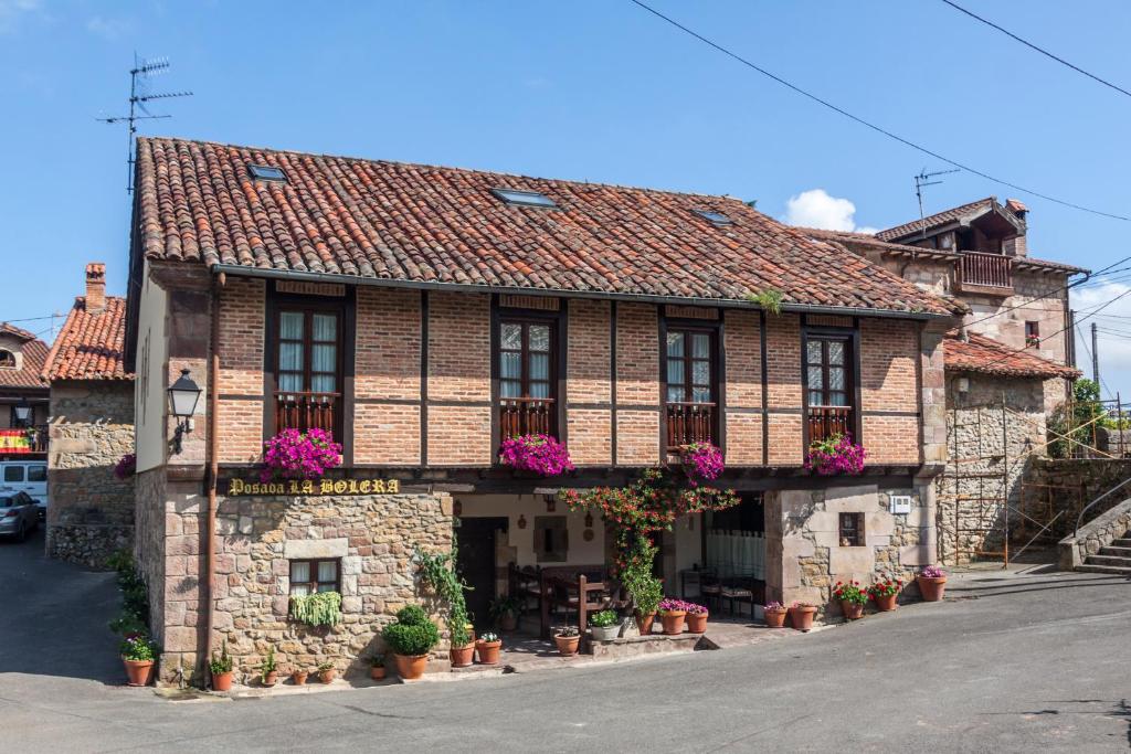 a building with flowers on the front of it at Posada La Bolera in Treceño