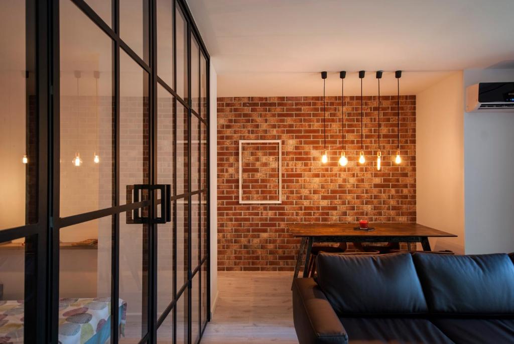 a living room with a couch and a brick wall at Retro MidTown Apartment in Bucharest