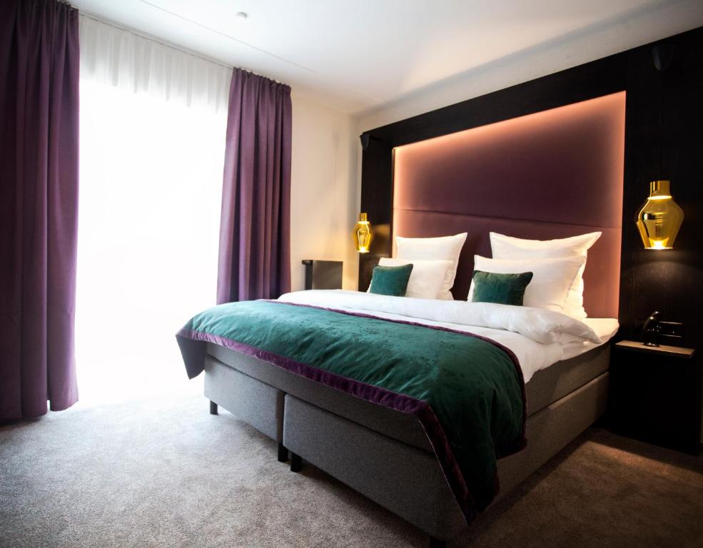 a bedroom with a large bed with a large window at ONNO Boutique Hotel & Apartments in Rendsburg