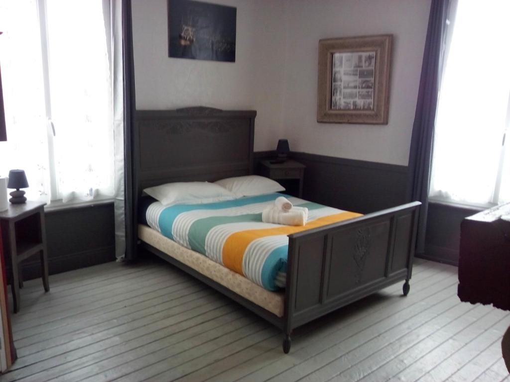 1 dormitorio con 1 cama con espejo grande en L'Ex-Voto, en Honfleur