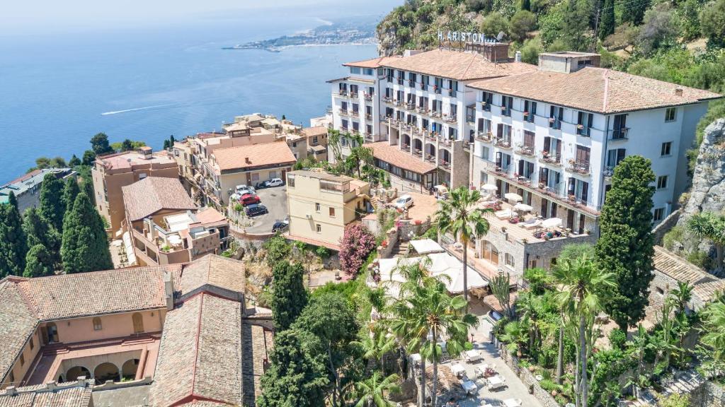 una vista aerea di una città su una collina con l'oceano di Hotel Ariston and Palazzo Santa Caterina a Taormina