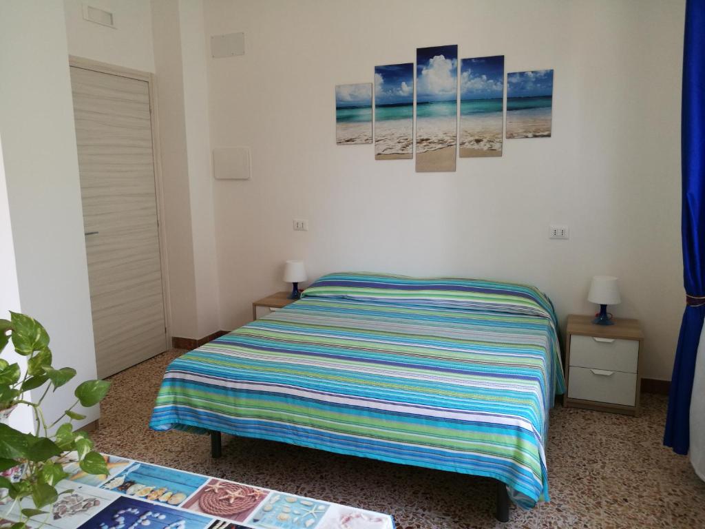 Un dormitorio con una cama con una manta a rayas. en B&B Laura e Chiara, en Trapani