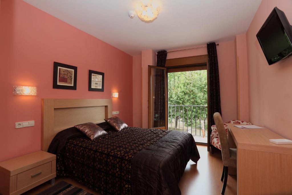 西古恩薩的住宿－哈西斯貴恩扎酒店，一间卧室配有一张床、一张书桌和一个窗户。