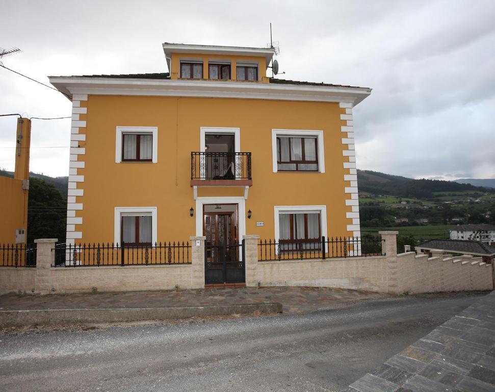 una casa amarilla al lado de una carretera en Casa Rubieira, en Sequeiro