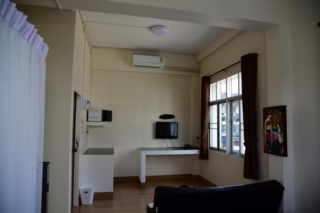 a living room with a couch and a window at Tk Home 3 in Lampang