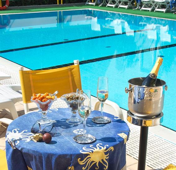 einen Tisch mit einer Flasche Wein und Weingläsern in der Unterkunft Hotel Gioiella Depandance in Bellaria-Igea Marina