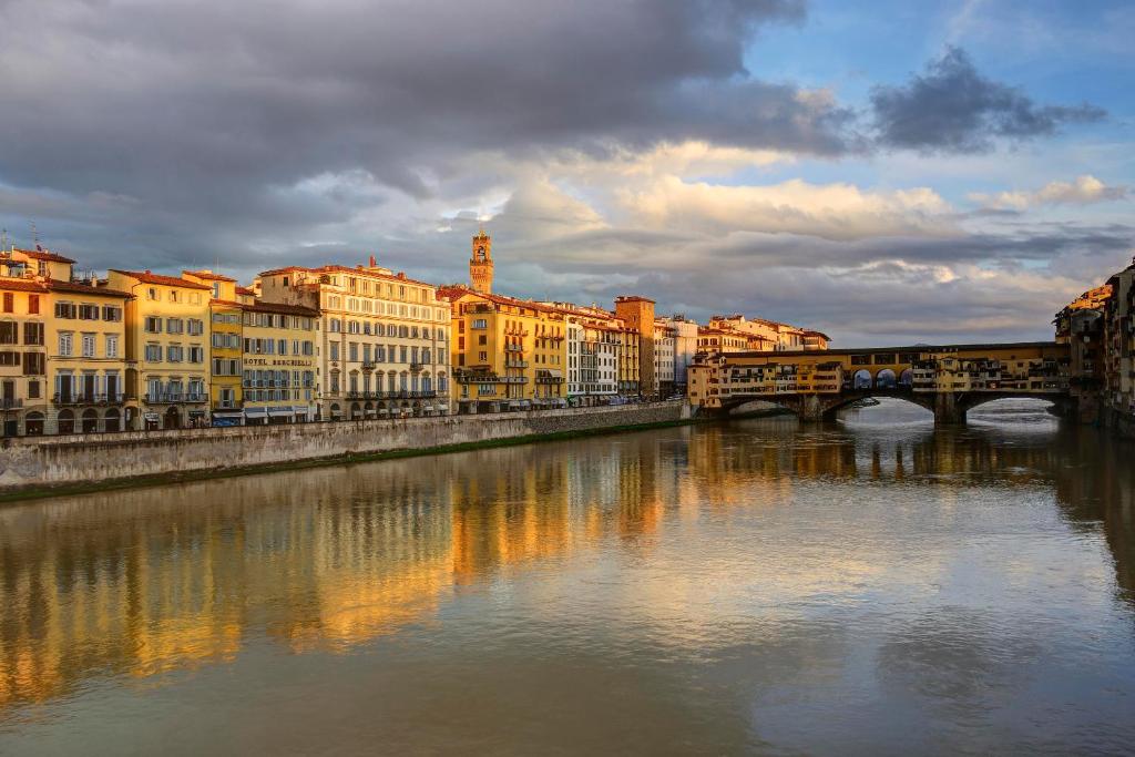 eine Brücke über einen Fluss in einer Stadt mit Gebäuden in der Unterkunft Hotel Berchielli in Florenz