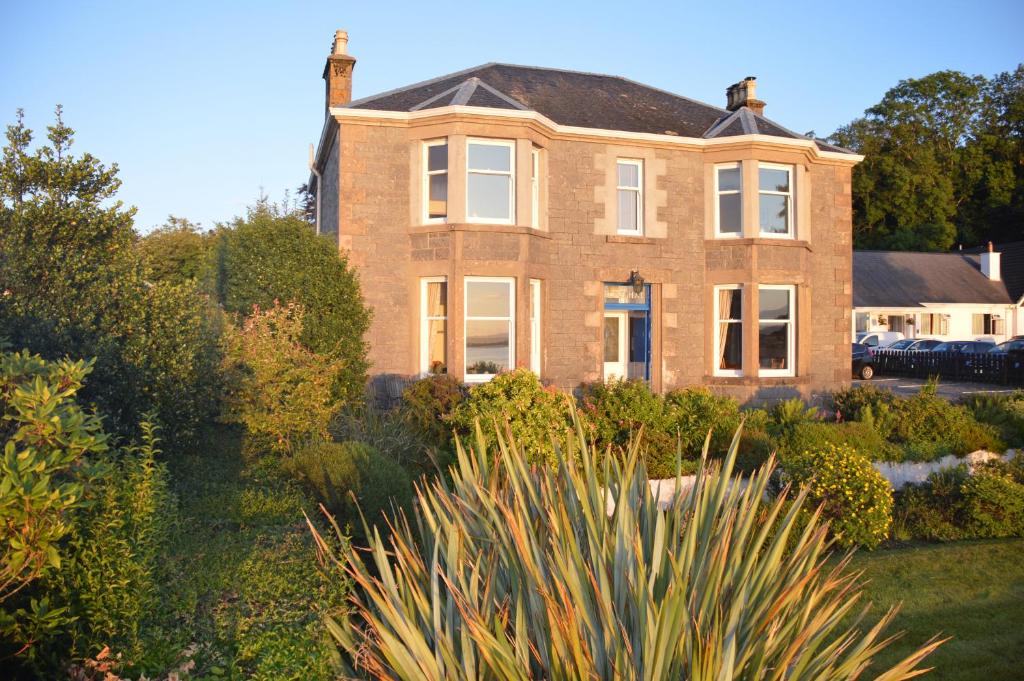 a large brick house with a garden in front of it at Ronebhal Guest House in Oban