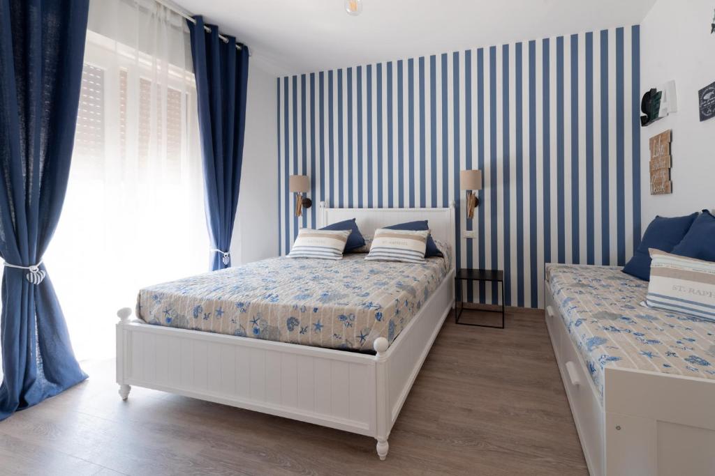 sypialnia z 2 łóżkami i niebieskimi zasłonami w obiekcie Dimora dei Sogni w mieście Civitanova Marche