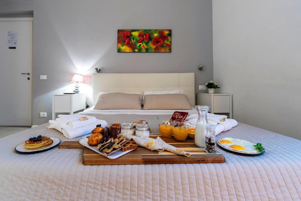 ローマにあるBella Roma Luxury Accommodation, Vatican City - Liberty Collectionのベッドの上に食べ物を載せた朝食トレイ