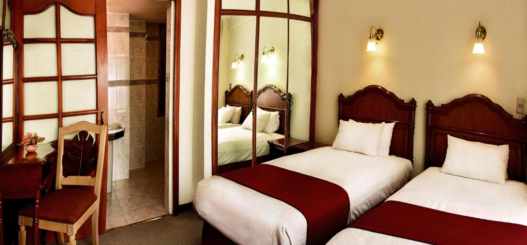 Pokój hotelowy z 2 łóżkami i lustrem w obiekcie Alcalá Apart Hotel w mieście La Paz