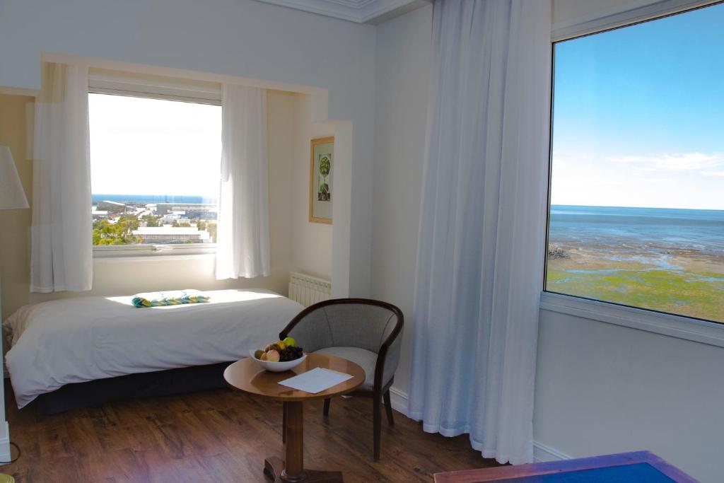 una camera da letto con un letto e una grande finestra di Lucania Palazzo Hotel a Comodoro Rivadavia