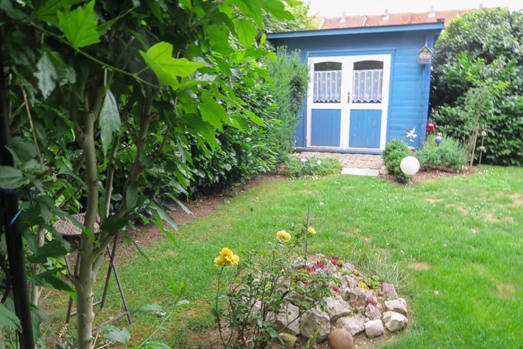 een tuin met een blauwe schuur en een tuin bij Ferienwohnung Eibl in Donaustauf
