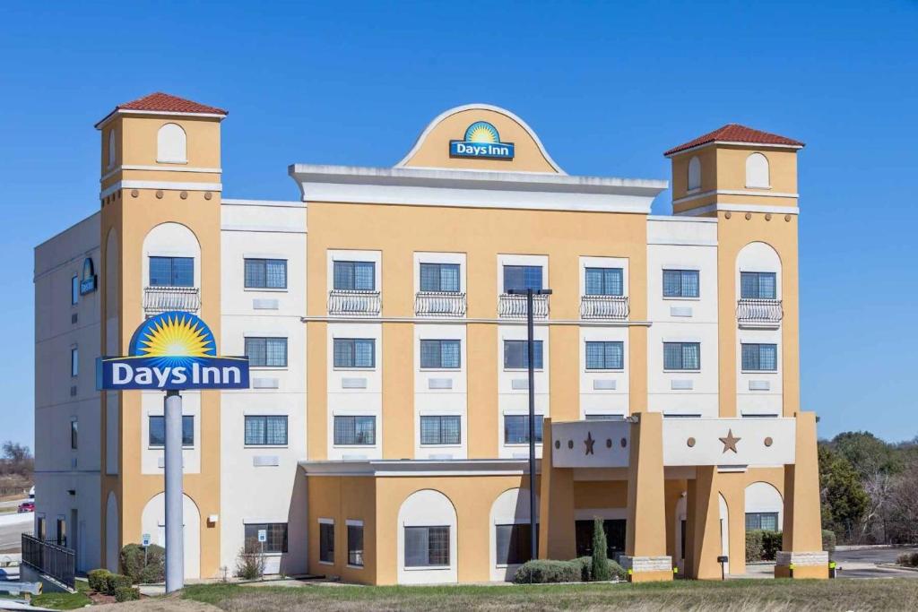 un bâtiment avec un panneau d'auberge de jour devant lui dans l'établissement Days Inn by Wyndham Salado, à Salado