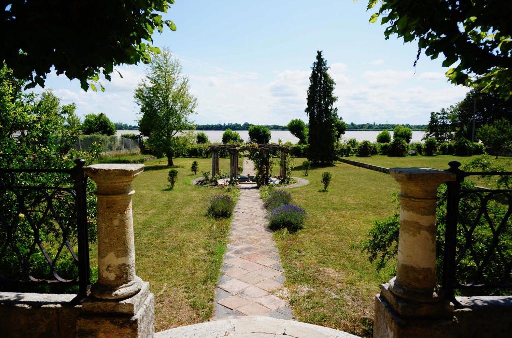 un jardín con un arco y un camino en Villa Bacchus en Bourg-sur-Gironde