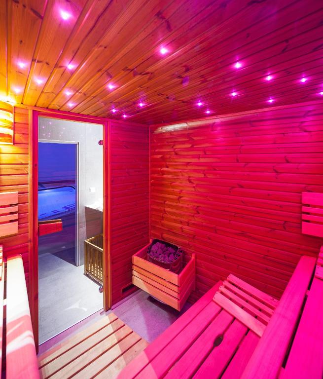 a red room with a bench in a sauna at Hotel Ostrov in Tisá