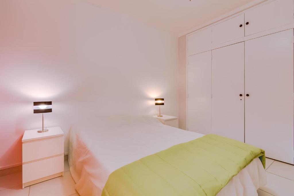 クアルテイラにあるTorre Azul 1Br - Near the beachの白いベッドルーム(ベッド1台、ナイトスタンド2台付)