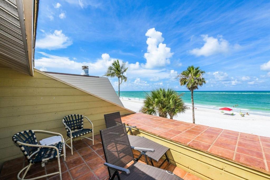 a house with chairs and a balcony with the beach at Fanta-Sea 47 by Beachside Management in Siesta Key