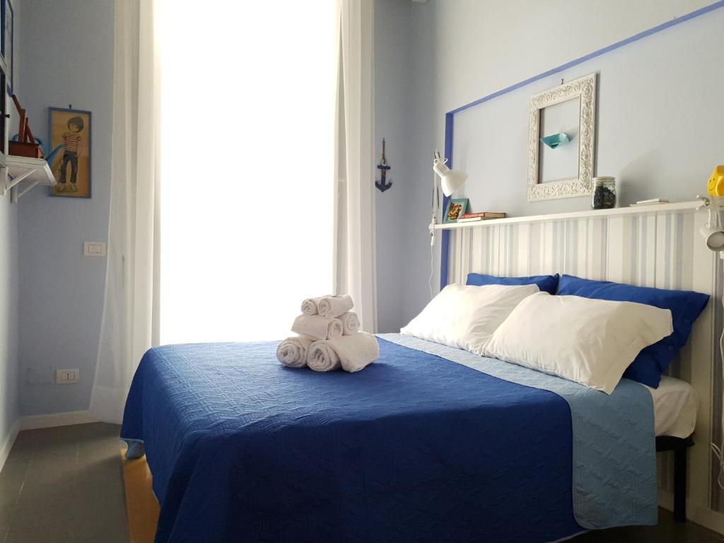 ein Schlafzimmer mit einem blauen Bett mit einem Teddybär darauf in der Unterkunft Viky's Home B&B in Neapel