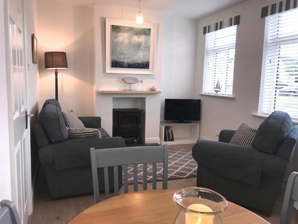 a living room with two couches and a table at The Links Cottage in Lahinch