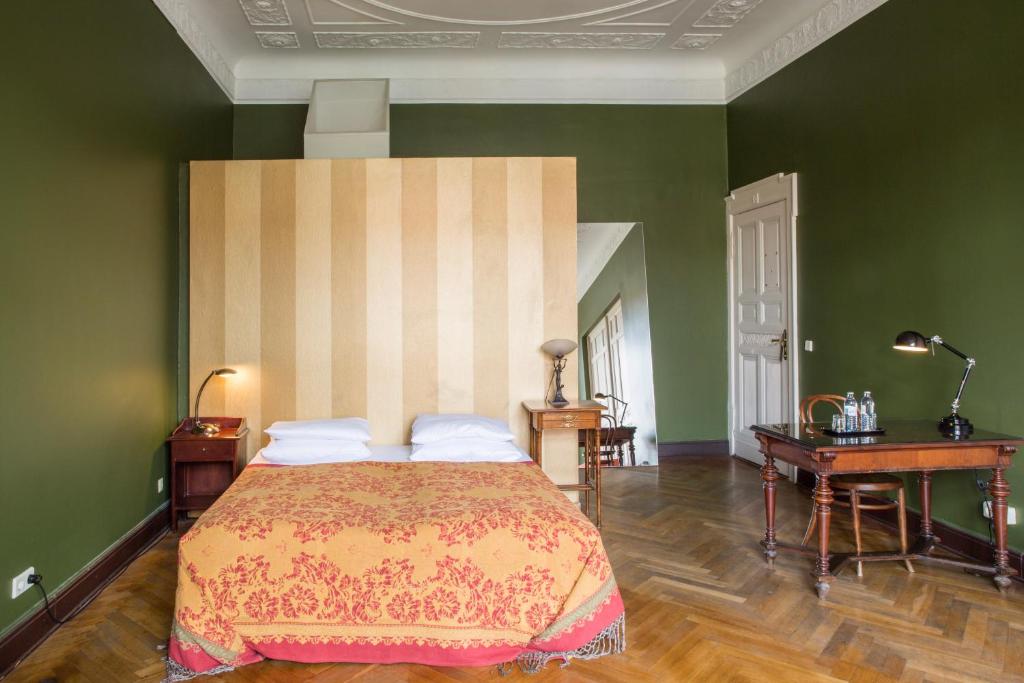 ベルリンにあるアールヌーボー ホテル アム クアフュルステンダムの緑の壁のベッドルーム1室(大型ベッド1台付)