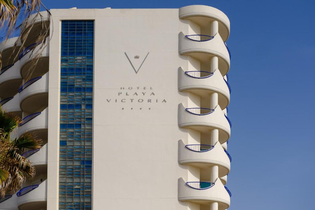 a building with balconies in front of a hotel at Hotel Playa Victoria in Cádiz