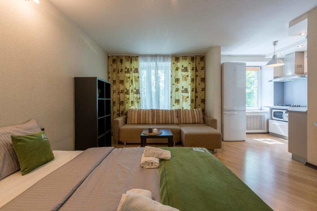 モスクワにあるAG Apartment Mashinostroenya 9/2のベッド1台、ソファ、リビングルームが備わります。
