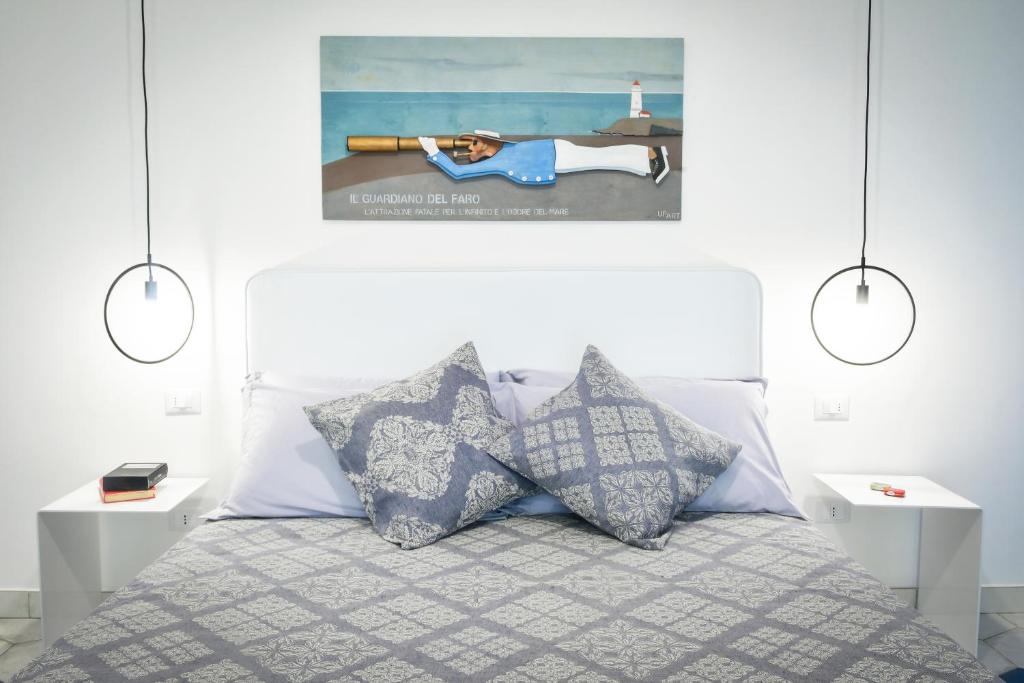 um quarto com uma cama com almofadas e uma fotografia na parede em Big Rose em Rossano