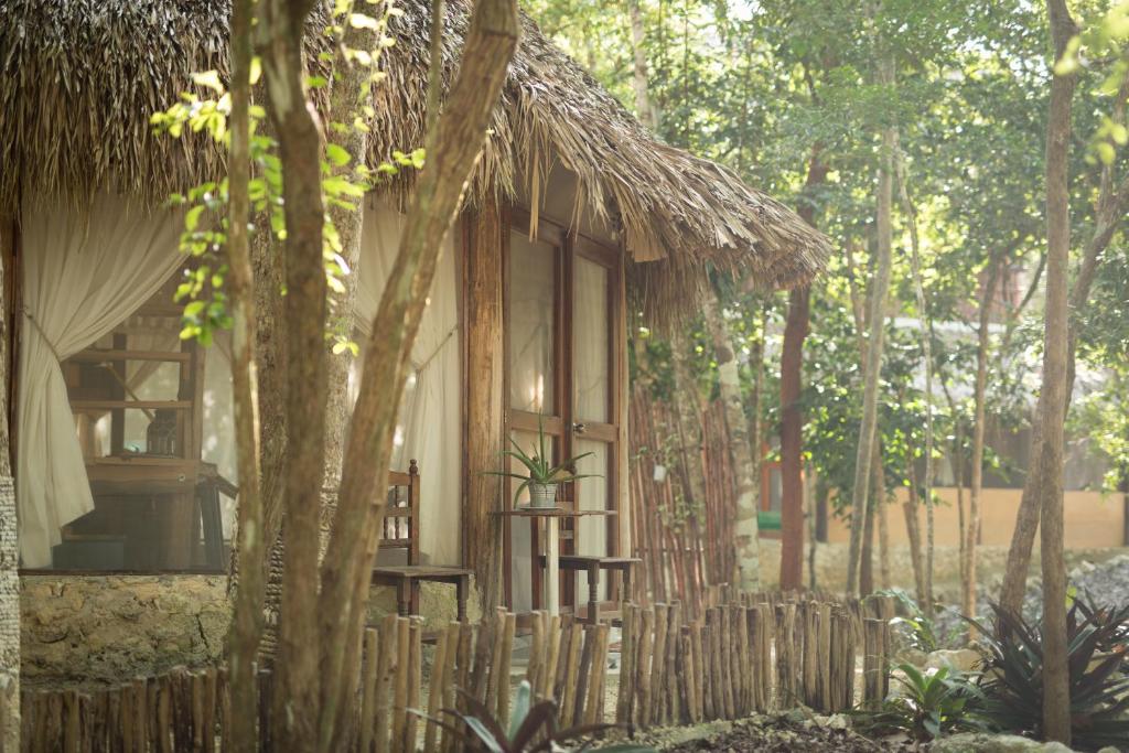 eine kleine Hütte mit einem Fenster und einem Zaun in der Unterkunft MELI-MELO P&B in Tulum