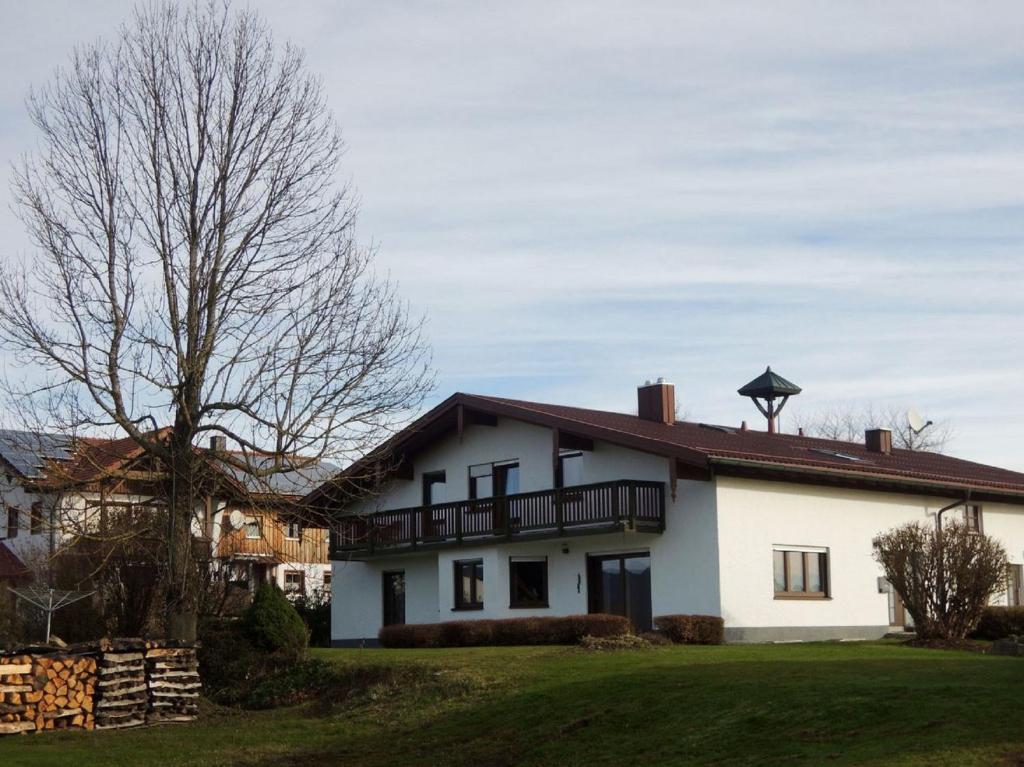 ein weißes Haus mit einem Balkon auf einem Hof in der Unterkunft Ferienwohnungen Hackl Ulrike in Mauth
