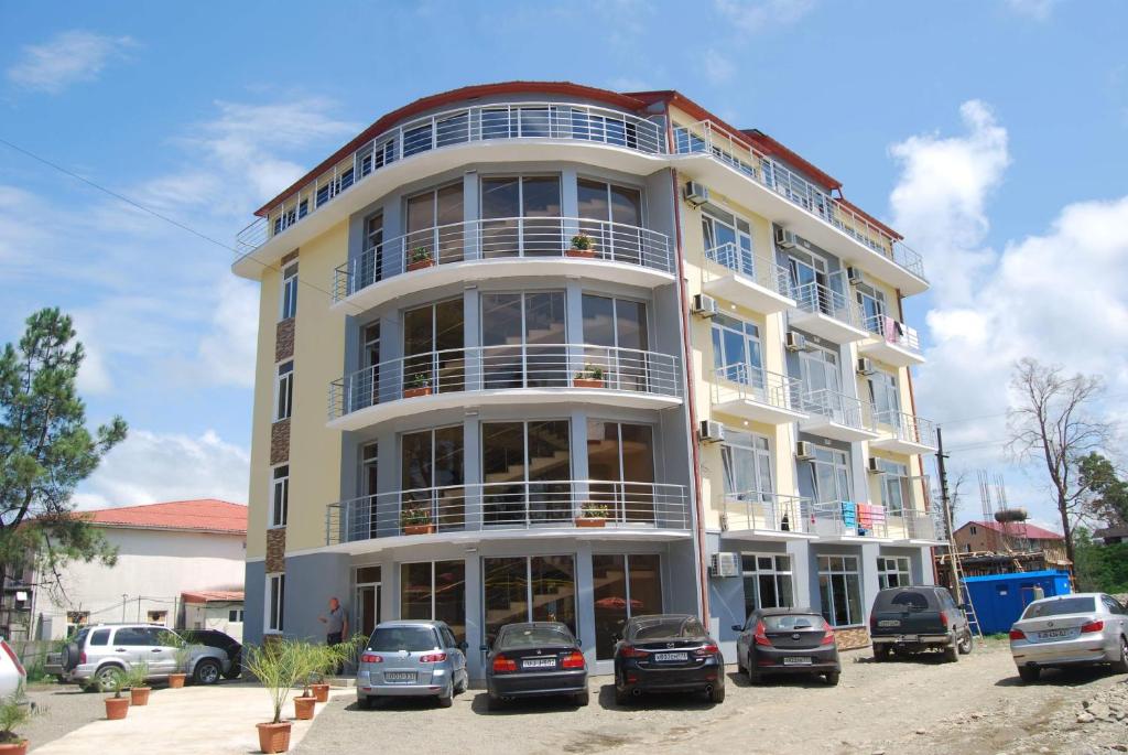 a white building with cars parked in front of it at David Palace Hotel Ureki in Ureki