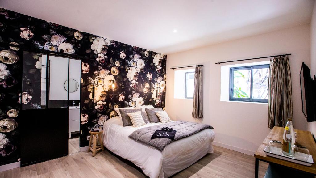 a bedroom with a large bed with a floral wall at Antichambre in Nîmes