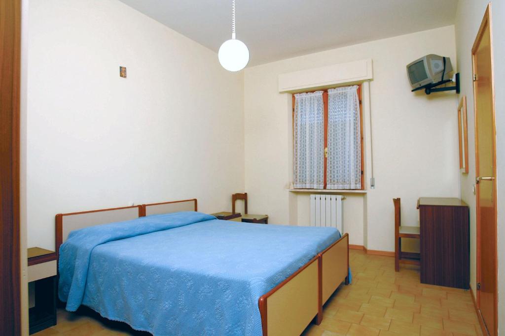 Un dormitorio con una cama azul y una ventana en Affittacamere Letizia Traballoni, en Esanatoglia