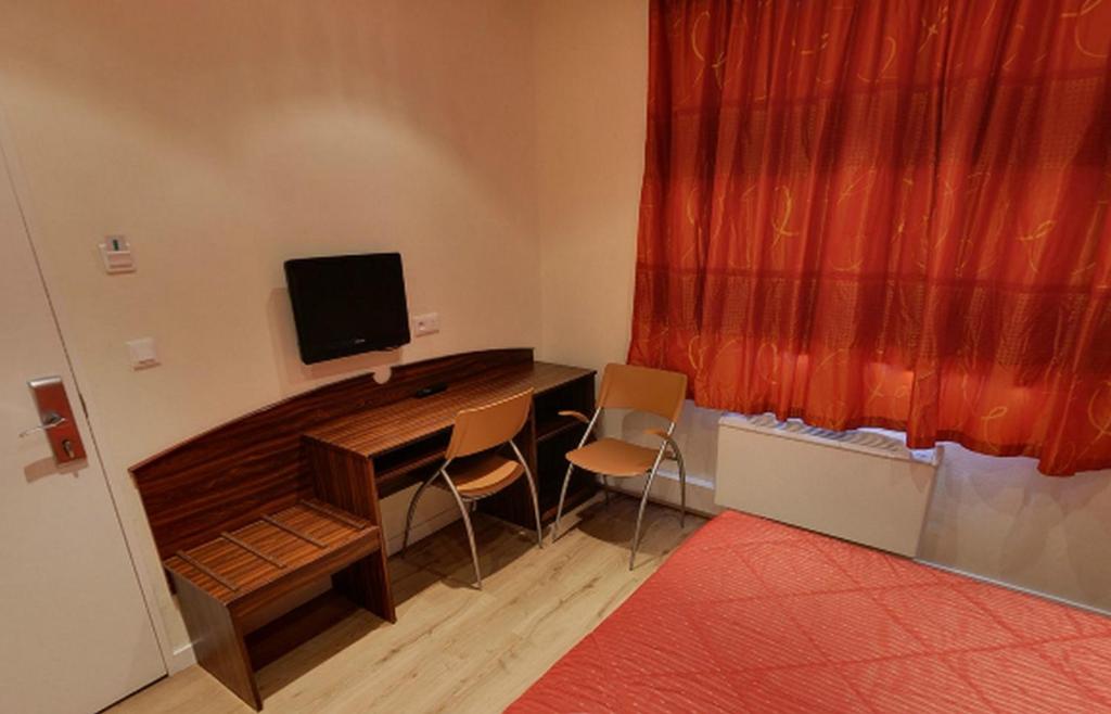 TV a/nebo společenská místnost v ubytování Hôtel Icare
