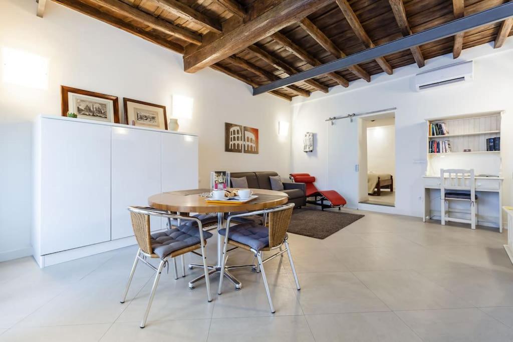 een keuken en een woonkamer met een tafel en stoelen bij Maison Romana Loft in Rome