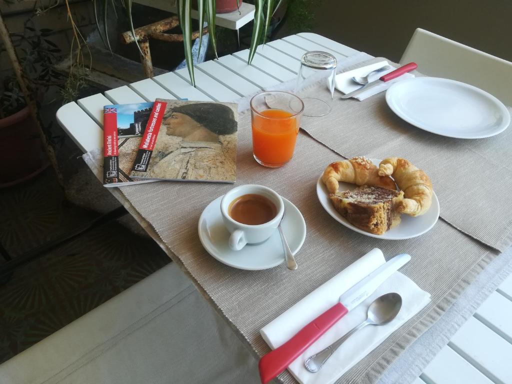 una mesa con una taza de café y un plato de comida en B&B Casa Mancini en Rímini