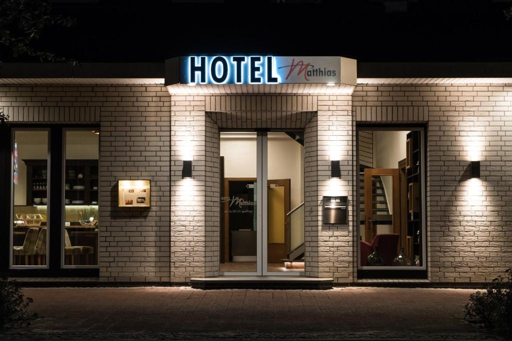 a hotel with a sign on the front of it at night at Hotel Matthias in Gnarrenburg