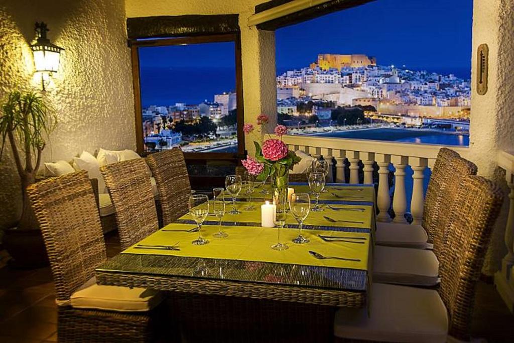 a table with wine glasses and a view of the city at Chalet Cerro in Peñíscola