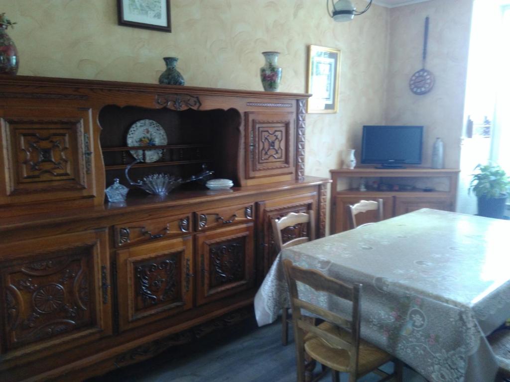 uma sala de jantar com uma mesa e um grande armário de madeira em Chez Mamie em Beynat