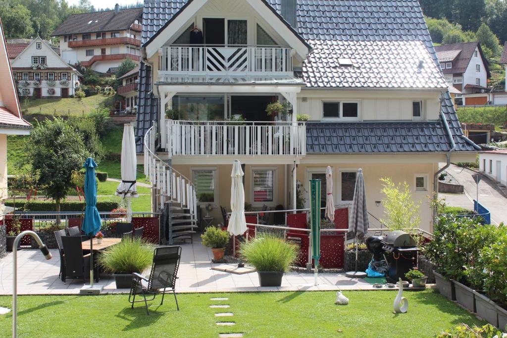 dom z dziedzińcem z krzesłami i parasolami w obiekcie Haus Lätsch w mieście Bad Peterstal-Griesbach