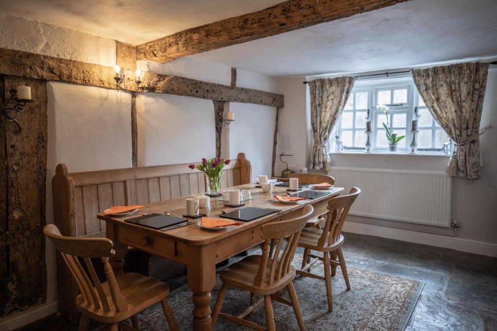 a dining room with a wooden table and chairs at Old Beams Bed & Breakfast in Alcester