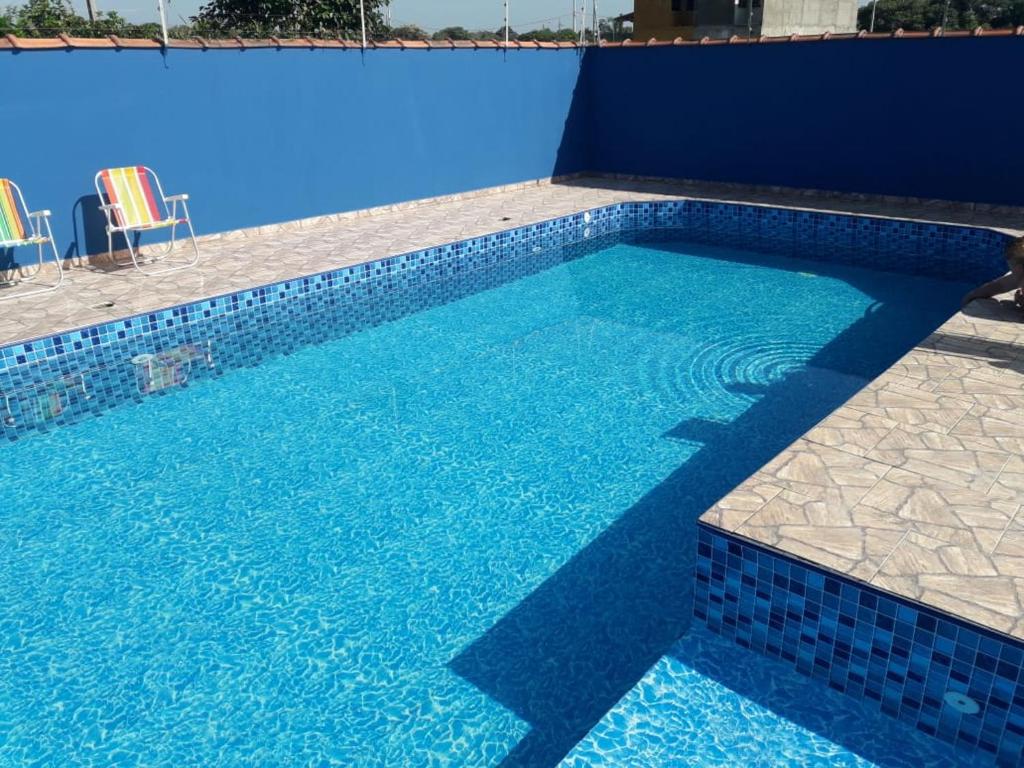 a swimming pool with a blue wall and blue tiles at Casa de Praia Piscina Gaivotas in Itanhaém