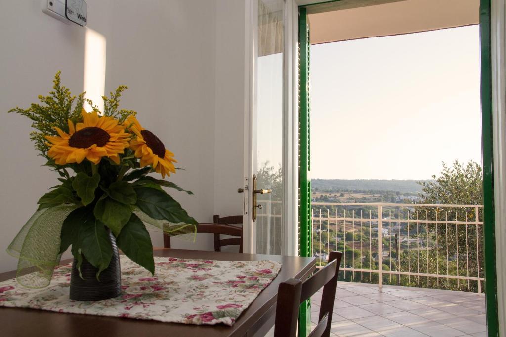 - une table à manger avec un vase de tournesols dans l'établissement Villa Anna, à Selva di Fasano