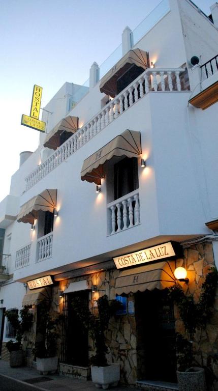 duży biały budynek z napisem w obiekcie Hostal Costa De La Luz w mieście Conil de la Frontera