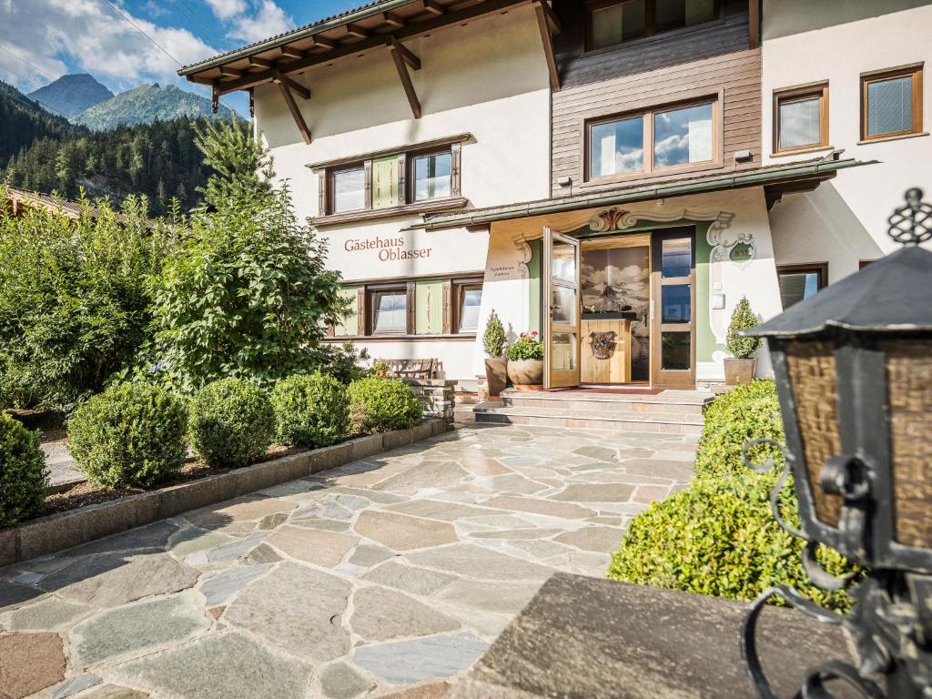 a house with a stone walkway in front of a building at Gästehaus Oblasser in Mayrhofen