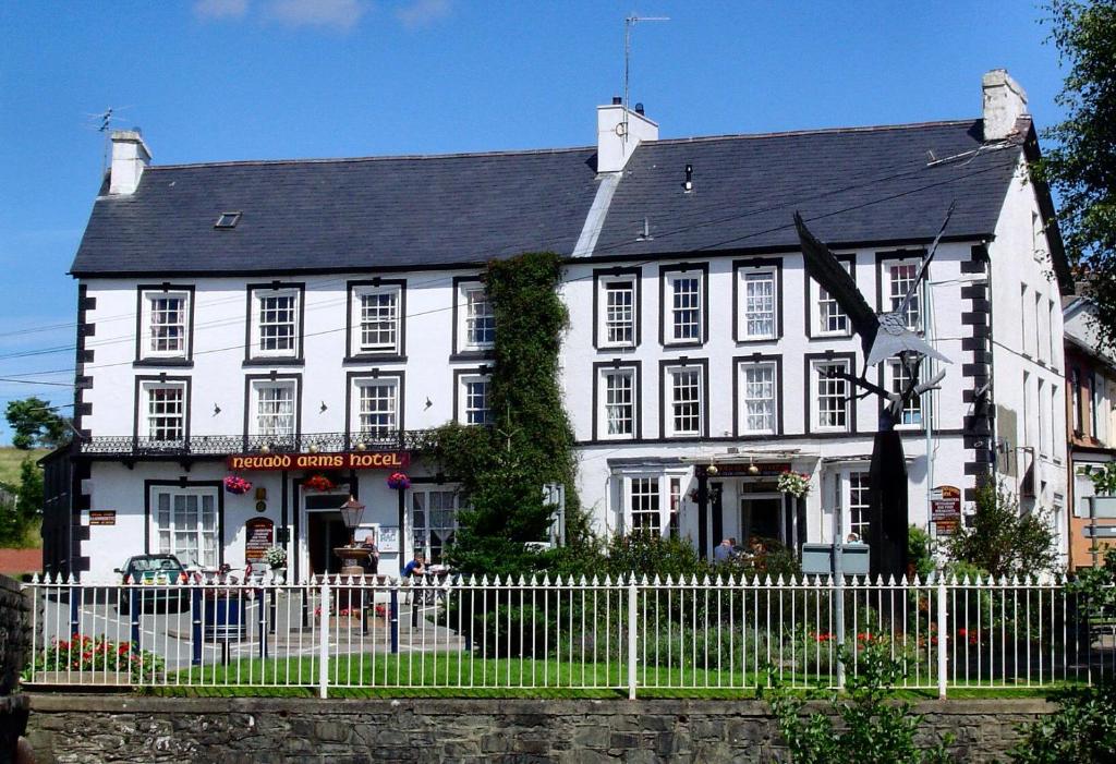 a white building with a fence in front of it at Neuadd Arms Hotel in Llanwrtyd Wells