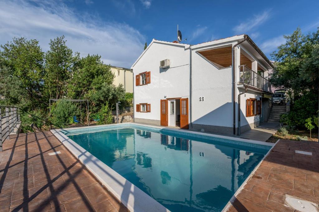 uma casa com piscina em frente a uma casa em Villa Lahor with private pool em Seget Vranjica